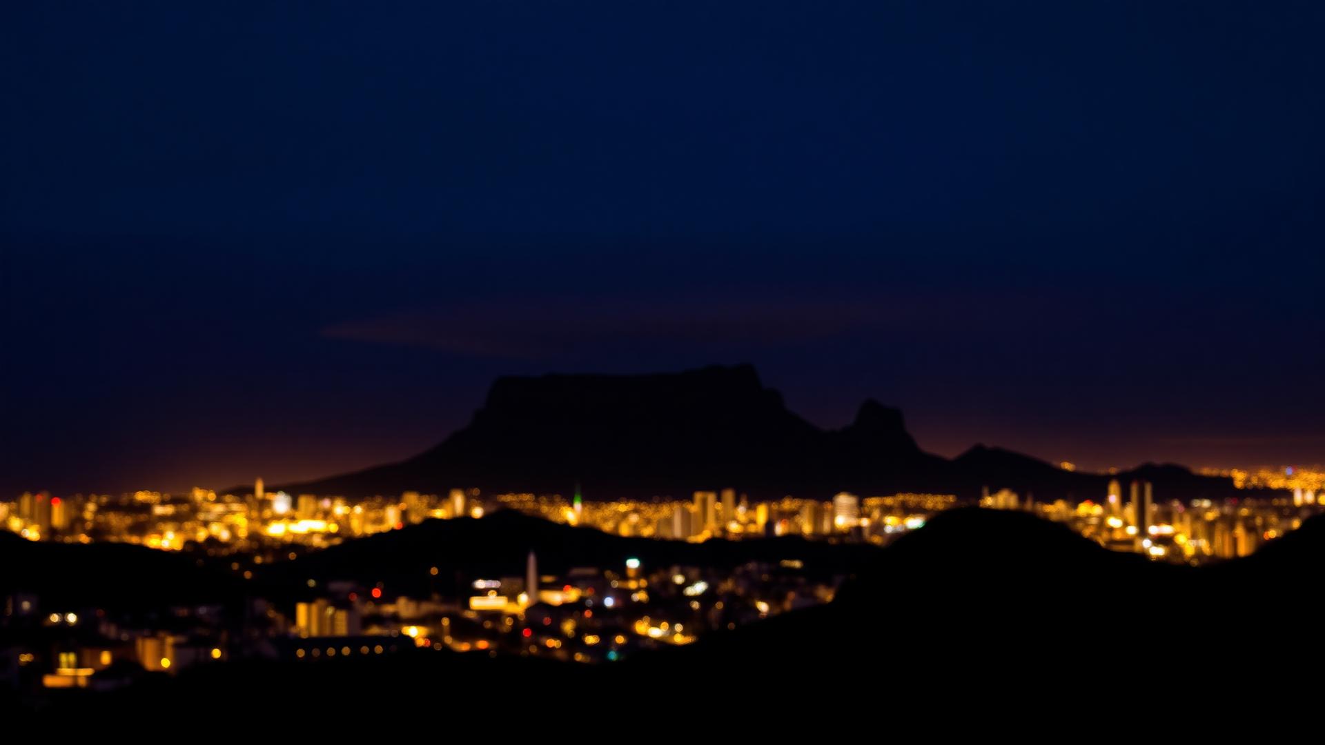 Cape Town city lights at night beneath Table Mountain